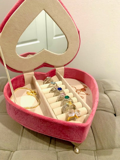 A image of a heart shaped jewelry box displaying rings